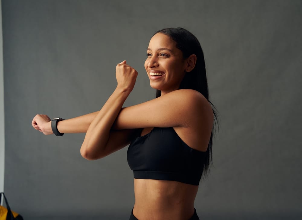 Happy,Young,Biracial,Woman,In,Sports,Bra,Doing,Cross,Arm Functional Wellness In Atlanta