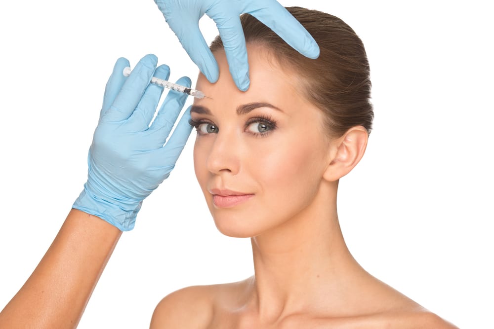 Beautiful young woman getting baby Botox injections into her forehead for a subtle, soft wrinkle-relaxing treatment.
